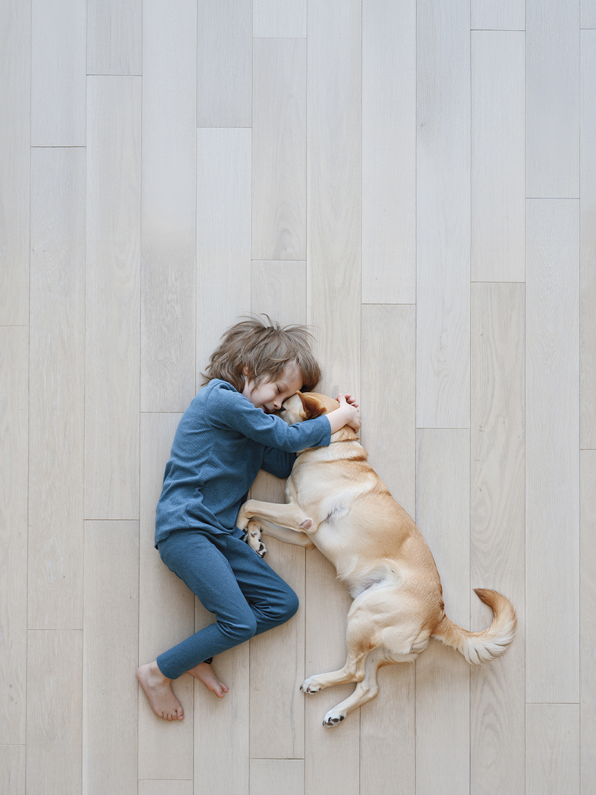 Child laying on Luxury Vinyl Floor with Dog.